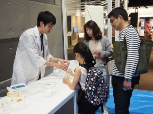 「石鹸の結晶を見てみよう」実験の説明をする、薬学部の永木英敏さん（1年次生）